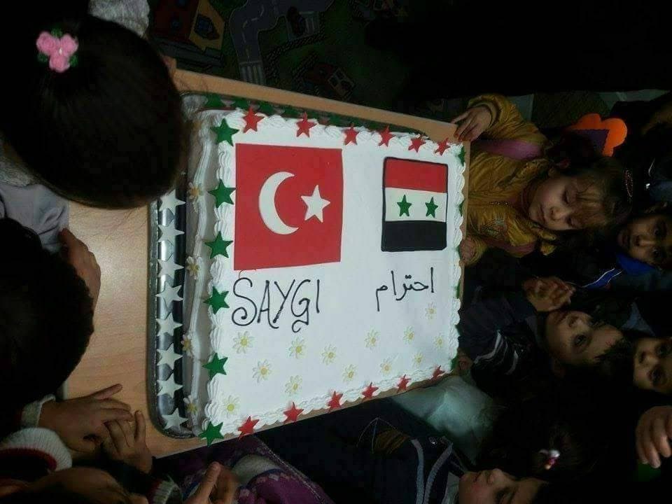 هل رُسِم (علم النظام السوري) على قالب حلوى في مخيم للنازحين بريف حلب؟